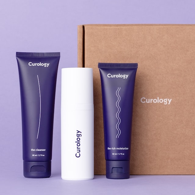 A set of beauty products with a plain purple background
