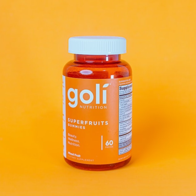 A bottle of Goli gummies in an orange backdrop