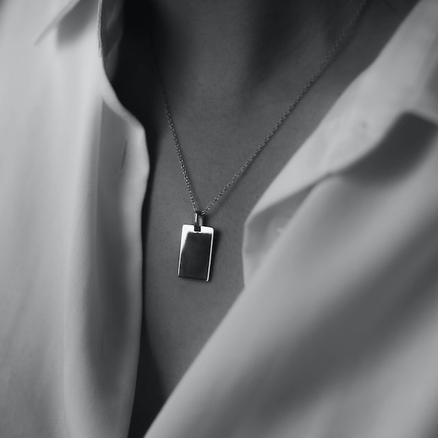 A grayscale photo of a necklace on a model
