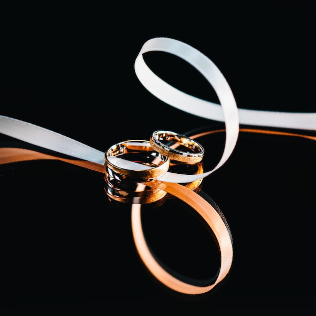 Two rings with ribbons on a reflective surface